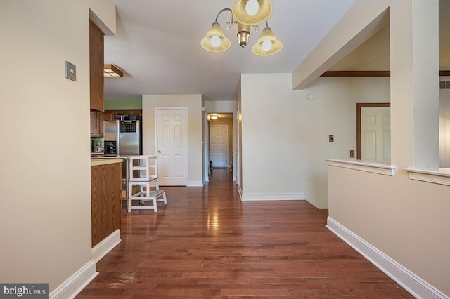 corridor featuring an inviting chandelier and dark hardwood / wood-style floors