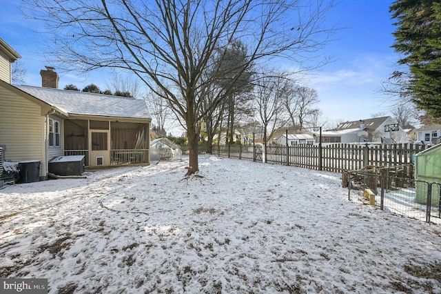 yard covered in snow featuring a sunroom