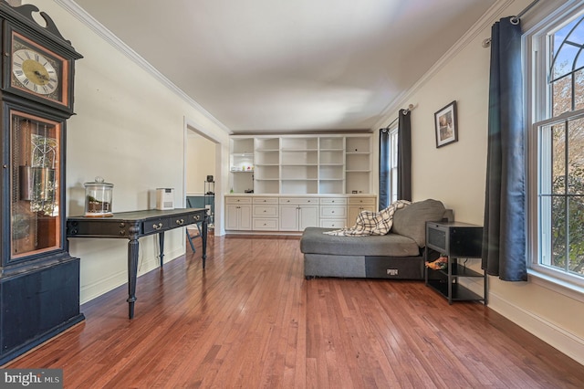 living area with built in features, ornamental molding, and wood-type flooring