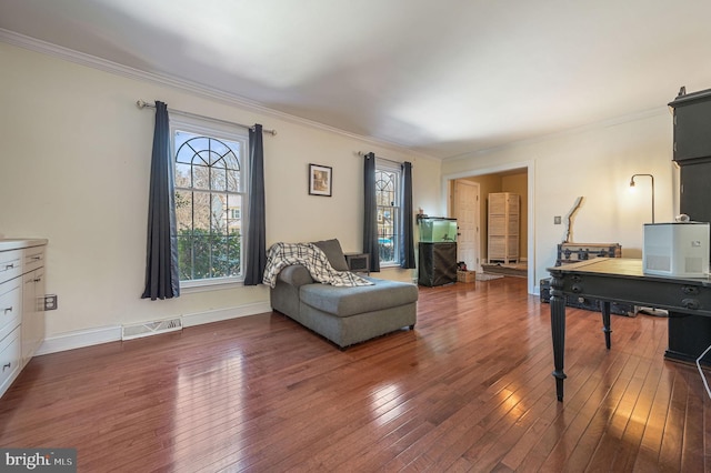 living area with crown molding and dark hardwood / wood-style floors