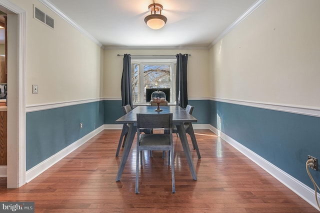 dining room featuring wood-type flooring and crown molding