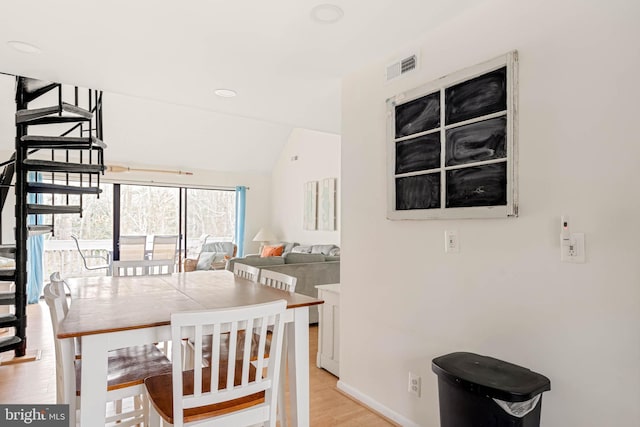 dining room with light hardwood / wood-style floors and lofted ceiling