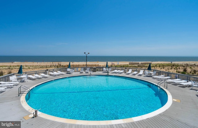 view of pool featuring a water view and a patio area