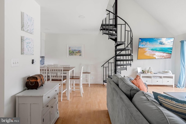 living room featuring lofted ceiling and light wood-type flooring