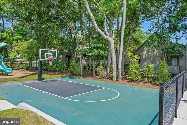 view of basketball court featuring a playground