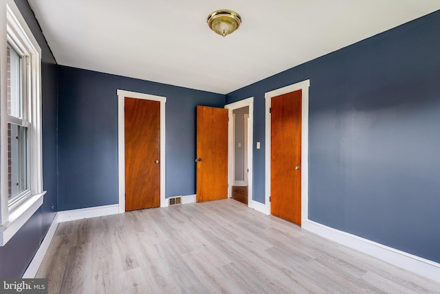 unfurnished bedroom with light hardwood / wood-style floors and a closet