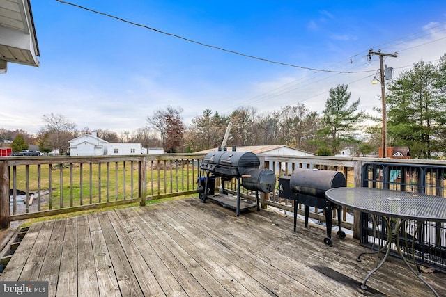 wooden deck with area for grilling and a yard