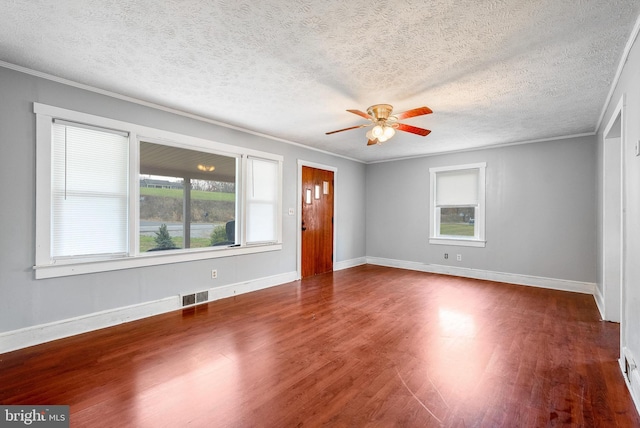 interior space with ceiling fan, dark hardwood / wood-style flooring, crown molding, and a textured ceiling