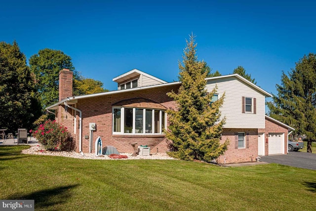 back of property with a lawn and a garage