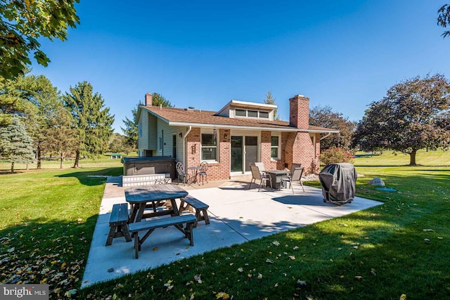 back of house with a patio area, a yard, and a hot tub