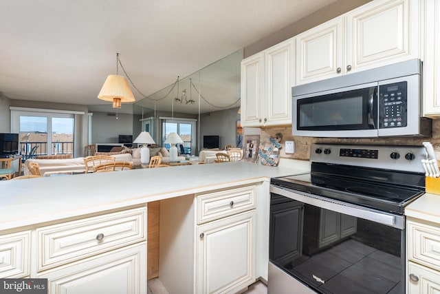 kitchen with kitchen peninsula, pendant lighting, and stainless steel appliances