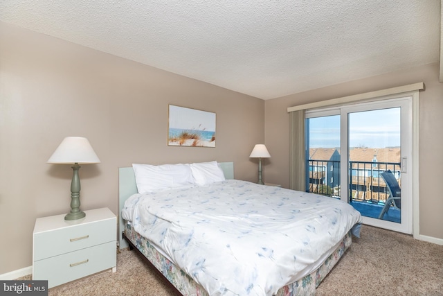 bedroom with access to exterior, light colored carpet, and a textured ceiling