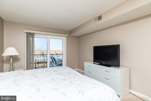 bedroom with access to exterior and a textured ceiling