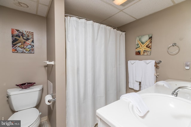 bathroom featuring a paneled ceiling, sink, and toilet