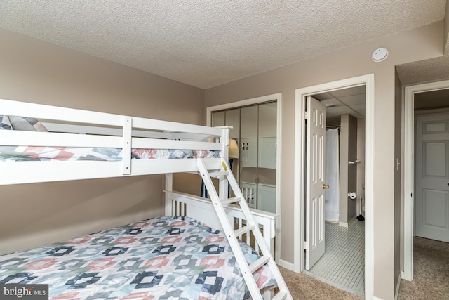 bedroom featuring carpet floors, a textured ceiling, and a closet