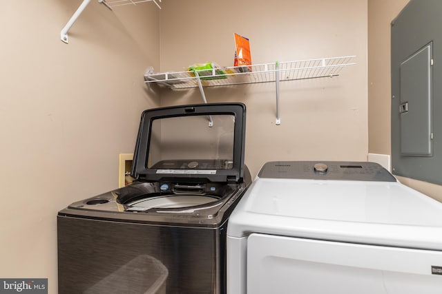 clothes washing area with independent washer and dryer and electric panel