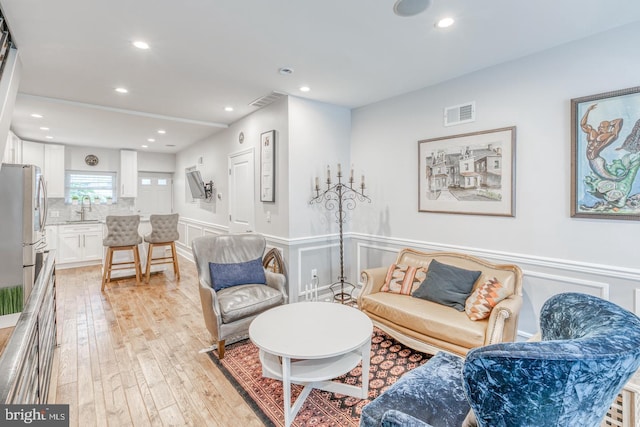 living room featuring light wood-type flooring and sink