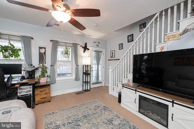 office space featuring a wealth of natural light, light carpet, and ceiling fan