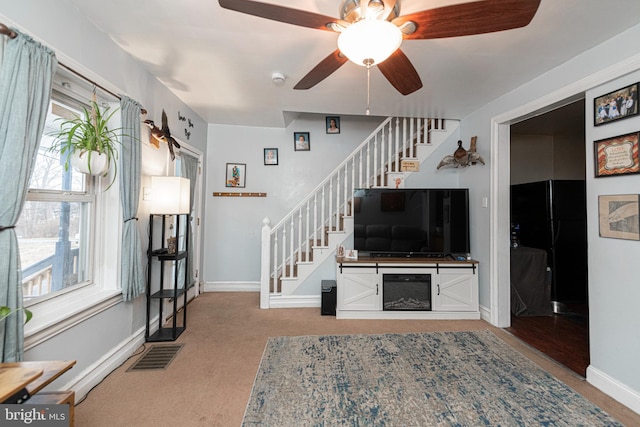 unfurnished living room featuring ceiling fan and light colored carpet