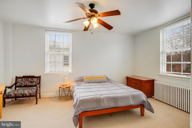 bedroom featuring ornamental molding, ceiling fan, light colored carpet, and radiator