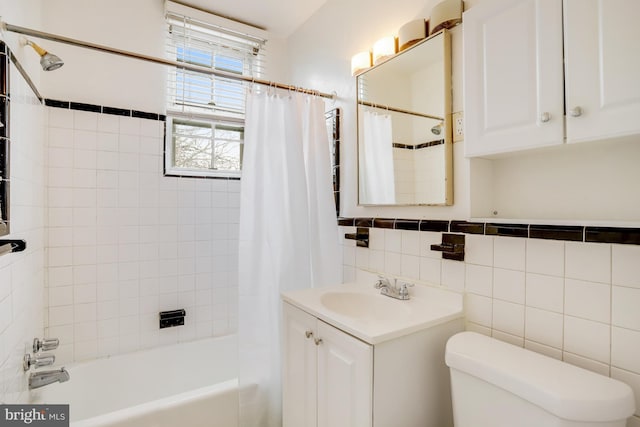 full bathroom with toilet, shower / tub combo with curtain, vanity, and tile walls