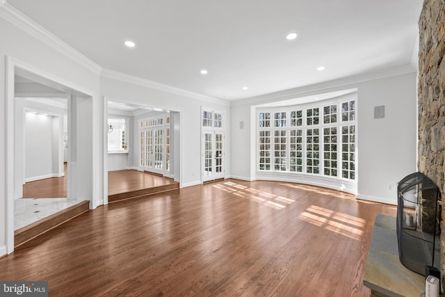 unfurnished living room with dark hardwood / wood-style flooring, a wood stove, and ornamental molding