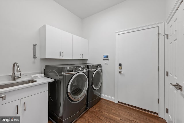 washroom with dark wood-type flooring, cabinets, separate washer and dryer, and sink