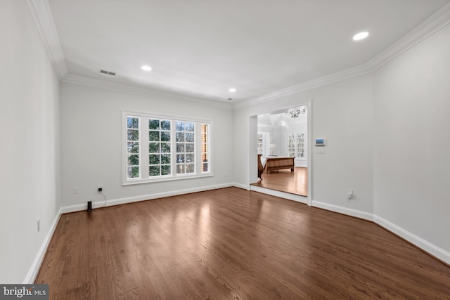 spare room with an inviting chandelier, crown molding, and hardwood / wood-style flooring