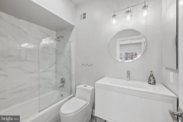 full bathroom featuring tiled shower / bath combo, vanity, and toilet