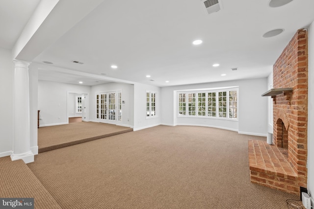 unfurnished living room featuring a brick fireplace and carpet