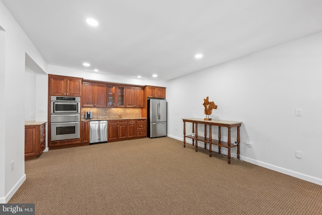 kitchen featuring backsplash, appliances with stainless steel finishes, and carpet