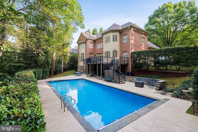 view of swimming pool with a deck and a patio