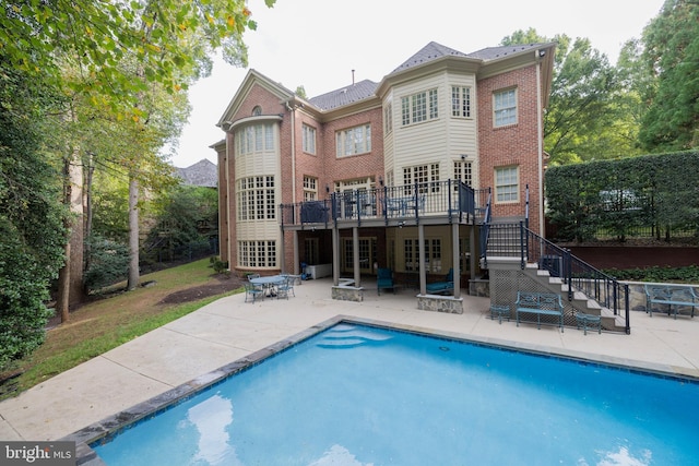 back of house with a swimming pool side deck and a patio