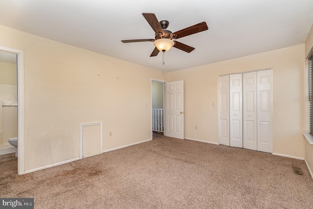 unfurnished bedroom featuring ensuite bath, a closet, ceiling fan, and carpet