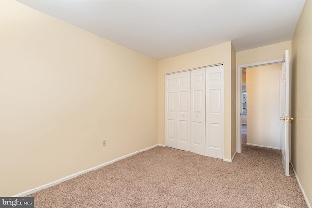 unfurnished bedroom featuring carpet and a closet