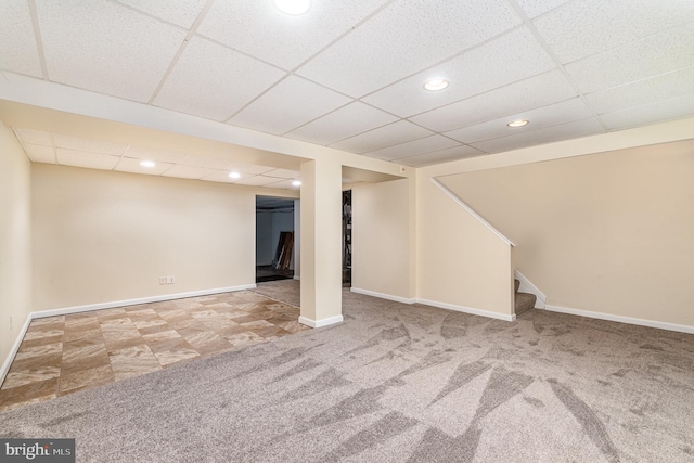 basement with carpet floors and a paneled ceiling