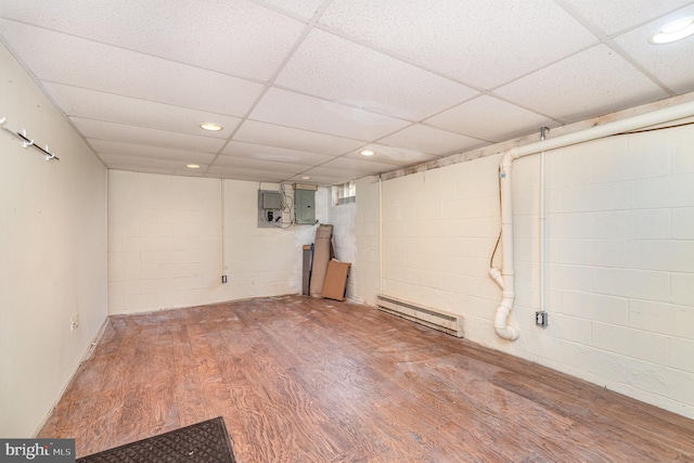 basement featuring hardwood / wood-style floors, a baseboard heating unit, a paneled ceiling, and electric panel