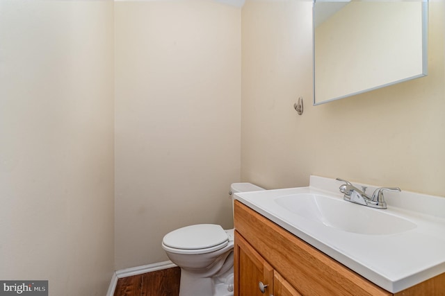 bathroom featuring vanity, hardwood / wood-style flooring, and toilet