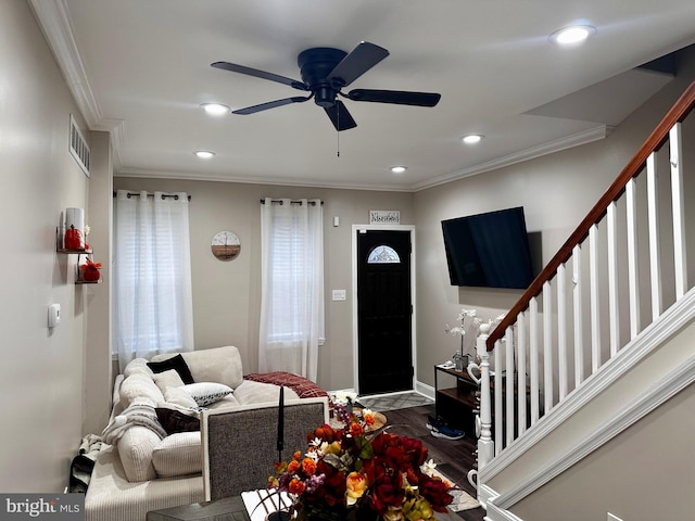 living room with hardwood / wood-style flooring, ceiling fan, and crown molding