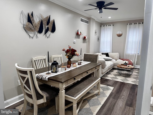 dining area with ornamental molding, ceiling fan, and dark wood-type flooring