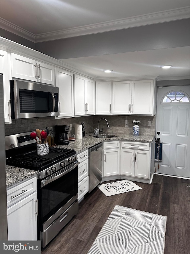 kitchen featuring backsplash, stainless steel appliances, white cabinetry, and sink