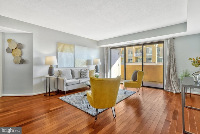 living room with wood-type flooring and a textured ceiling