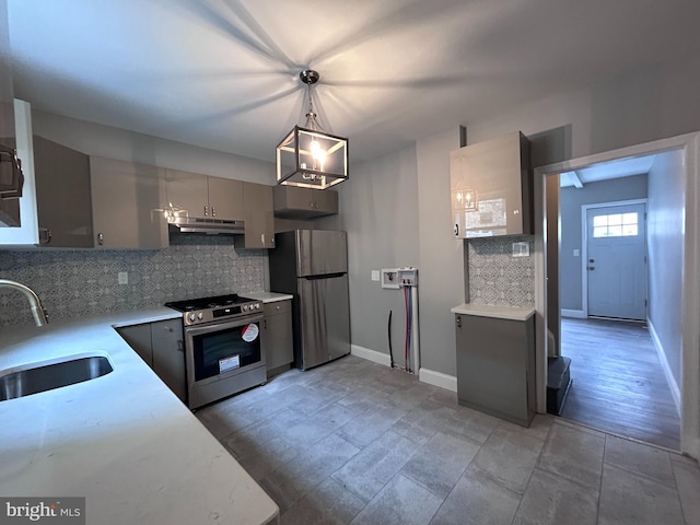 kitchen featuring gray cabinetry, backsplash, sink, decorative light fixtures, and stainless steel appliances