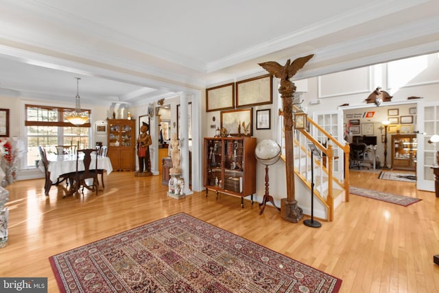 interior space with wood-type flooring, decorative columns, ceiling fan, and ornamental molding