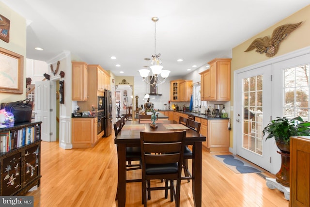 dining area with a chandelier, light hardwood / wood-style floors, and sink