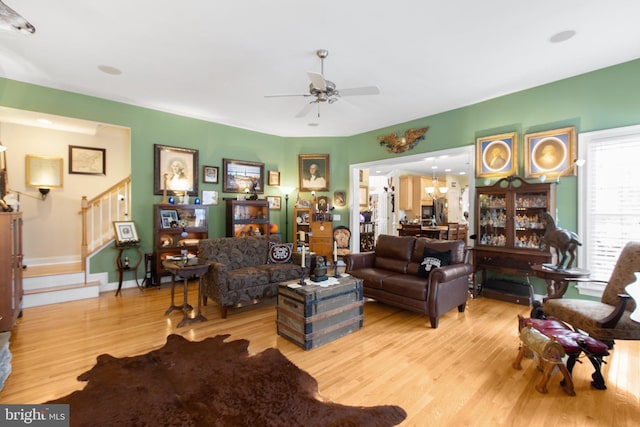 living room with ceiling fan and light hardwood / wood-style flooring