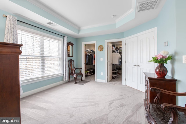 sitting room featuring light colored carpet, ornamental molding, and a tray ceiling