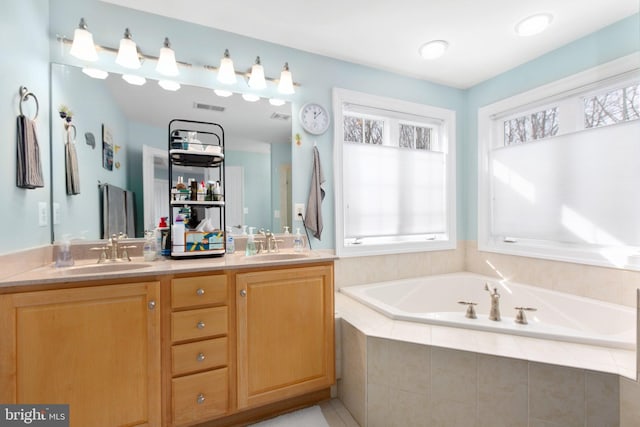 bathroom featuring vanity and tiled tub