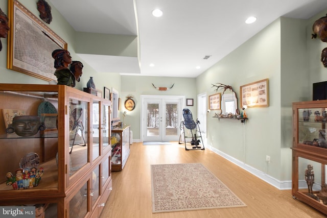 foyer with light hardwood / wood-style floors and french doors