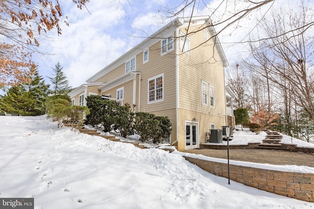 snow covered property featuring central AC unit